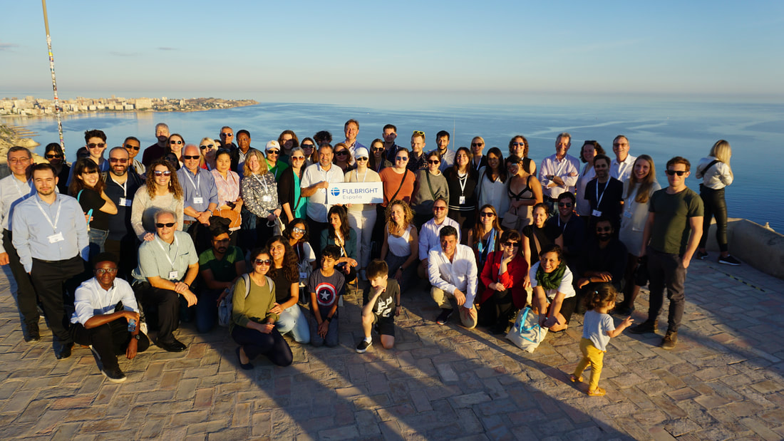 Photo of a diverse group of Fulbright researchers at a viewpoint at sunset overlooking the Alicante, Spain coast